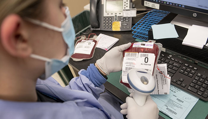 Female blood bank worker handling blood samples