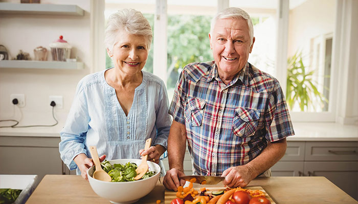 Elderly couple making salad