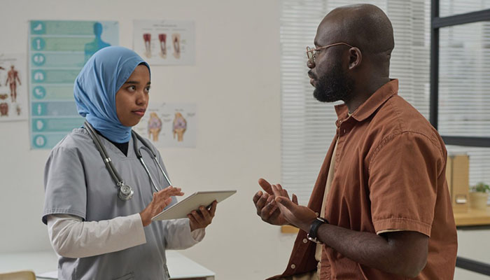 Female doctor speaking to male patient