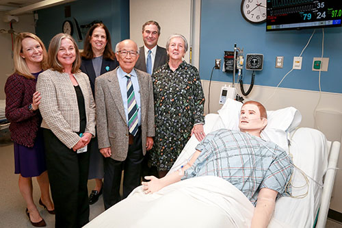 Group of medical professionals standing with patient model used for training